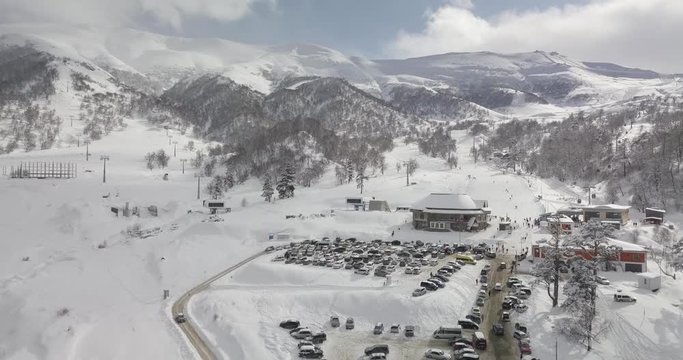 Aerial shot of ski resort bakuriani, Didveli area, in shot car parking, ski gondola lift station, group of people and skiers in winter