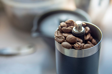 Coffee beans in a hand grinder, Pour roasted coffee beans into a manual coffee grinder