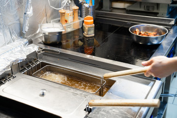 Boiling oil in deep fryer in restaurant kitchen.