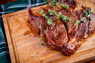 A Juicy Hot steak with rosemary on a wooden Board