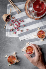 tea made from tea rose petals in a glass bowl on drak black rustic background