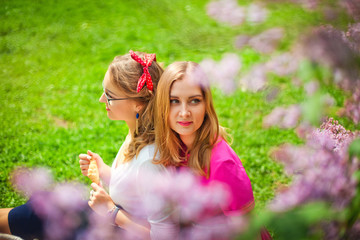 Obraz premium girls on a picnic in a blooming garden