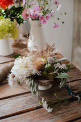 Female professional florist prepares the arrangement of wild flowers.