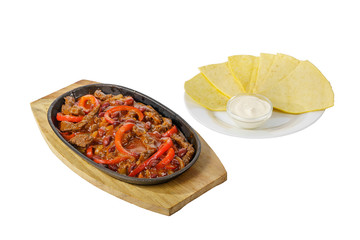 fajita, beans and bell peppers with meat, beef, lamb, tortilla and sour cream sauce, fried, baked portion on a hot frying pan, on a wooden board on a white background Side view. For the menu