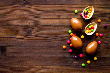 Chocolate eggs - Easter symbol - frame on dark wooden background top-down copy space