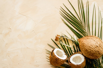Fototapeta na wymiar Coconut background with oil on beige background top-down copy space