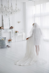 bride walks around the room with a wedding dress