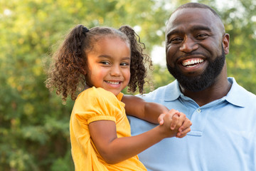 Father laughing and playing with his daugher.
