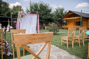 wedding ceremony arch decorated with flowers with chairs