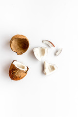 Cut coconuts - halfs and pieces - on white background top-down copy space