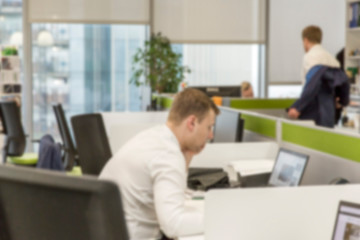 People work at computers in a modern office. Blurred.