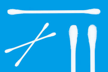 Cotton swabs isolated on blue background. Top view ear sticks