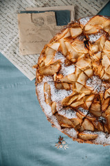 Rustic, traditional, apple pie on the blue table, old letters in the background