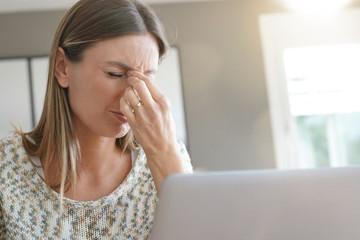 Fototapeta na wymiar Woman in front of laptop having a headache