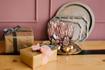 The decor of Christmas and New year. Pink kitchen with grove glasses, trays and gifts