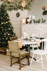 The decor of Christmas and New year. Living room with Christmas tree, fireplace and festive table