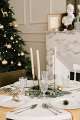 The decor of Christmas and New year. Living room with Christmas tree, fireplace and festive table