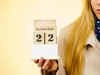 Woman holding calendar with first autumn day