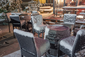 tables and chairs in a cafe, snow covered
