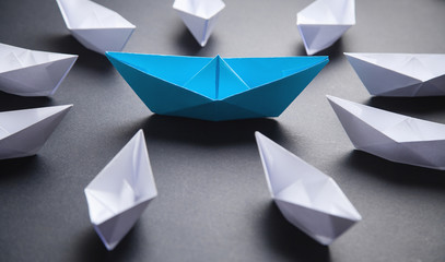 Blue and white paper boat. Leadership concept
