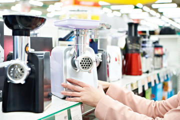 Electric meat grinder in buyer hand at store