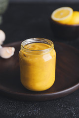 Jar of tasty honey mustard sauce on dark background