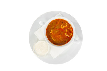 Solyanka, pickle with sour cream, On a napkin in a white plate, isolated white. Serving dishes in a cafe, restaurant, for a menu, View from above