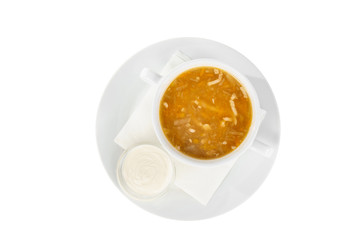 Soup transparent with chicken, fish, cabbage soup, in plate isolated white and sour cream, on a napkin. Serving dishes in a cafe, restaurant, for a menu. View from above
