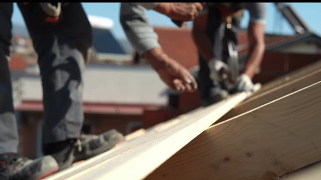 Construction crew working on the roof sheeting of a new, luxury residential home