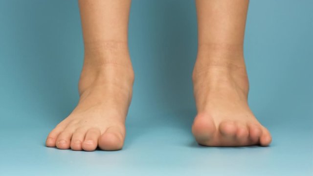 Close up of bare child feet on blue background.