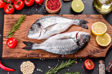 Raw dorado fish with spices cooking on cutting board