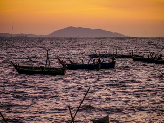 Photos of the small fishing boat moored in the ocean.