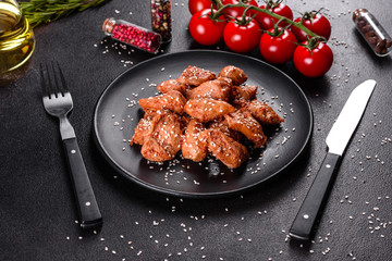 Chicken fillet in sesame seeds, teriyaki sauce on a black stone plate