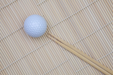 Top View With Bamboo Chopsticks and Mat and Golf Balls.