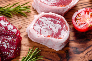 Fresh Raw Beef steak Mignon, with salt, peppercorns, thyme, tomatoes