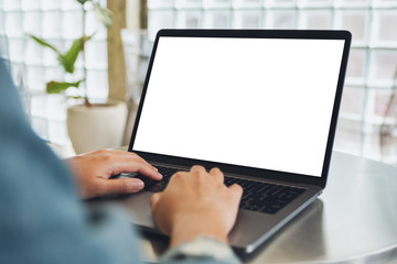 Mockup image of a woman using and typing on laptop computer with blank white desktop screen