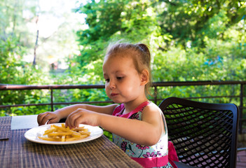 child eats french fries. not healthy food