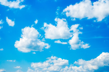Naklejka na ściany i meble Blue sky background with white fluffy clouds
