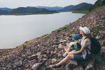 Naklejka premium Happy family sitting near a lake at the day time.