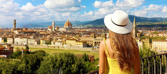 Woman in yellow dress and hat looks at stunning panoramic view of Florence, Italy. Happy pretty...