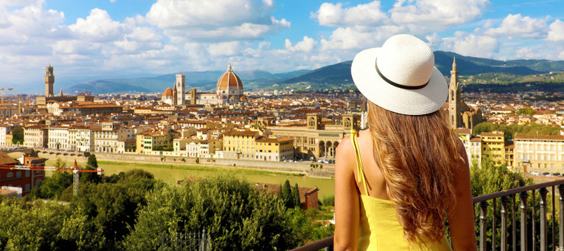 Woman in yellow dress and hat looks at stunning panoramic view of Florence, Italy. Happy pretty girl in Tuscany with Florence cityscape, banner view.