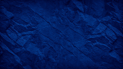 Blue grunge background. Toned mountain texture. Close-up. Navy blue rocky texture with copy space...