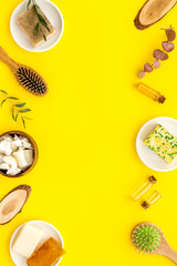 Hair care concept. Coconut oil, brush on yellow background top-down frame copy space