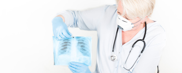 Close-up of a mature caucasian doctor with blond hair wearing a face mask to protect herself from coronavirus infection or air pollution.