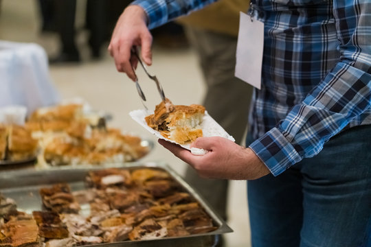 Man serving himself with food on banquet or celebration event. - Powered by Adobe