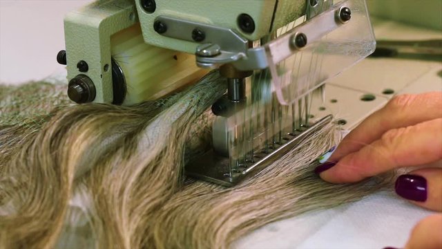 Wig manufacturing process, woman collects a wig. Wig assembly close-up