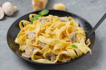 Italian fettuccine pasta with mushrooms, Parmesan cheese and cream sauce, selective focus. 