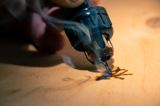 Wood burning with pyrography pen. Close up