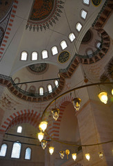 Fototapeta premium The interior of the 16th century Suleymaniye mosque, the largest Ottoman mosque in Istanbul, Turkey. Focus on the foreground lights
