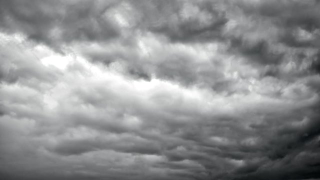 Ominous dark grey storm clouds in dramatic sky. Natural timelapse